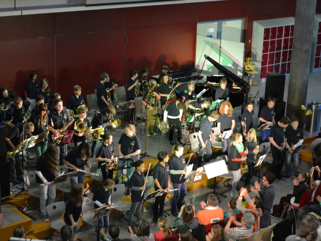 Schulorchester spielt vor dem Publikum im Foyer.